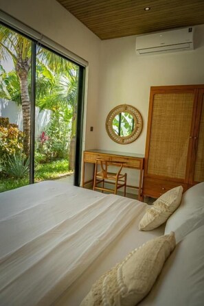 A bedroom with a large bed, a desk, and a wardrobe. - Paje Emerald Escapes (Zanzibar)