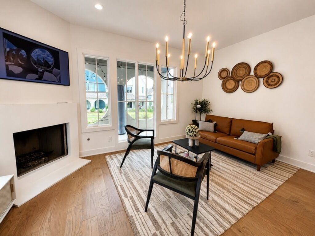 A living room with a fireplace, a sofa, a coffee table, and a chandelier.