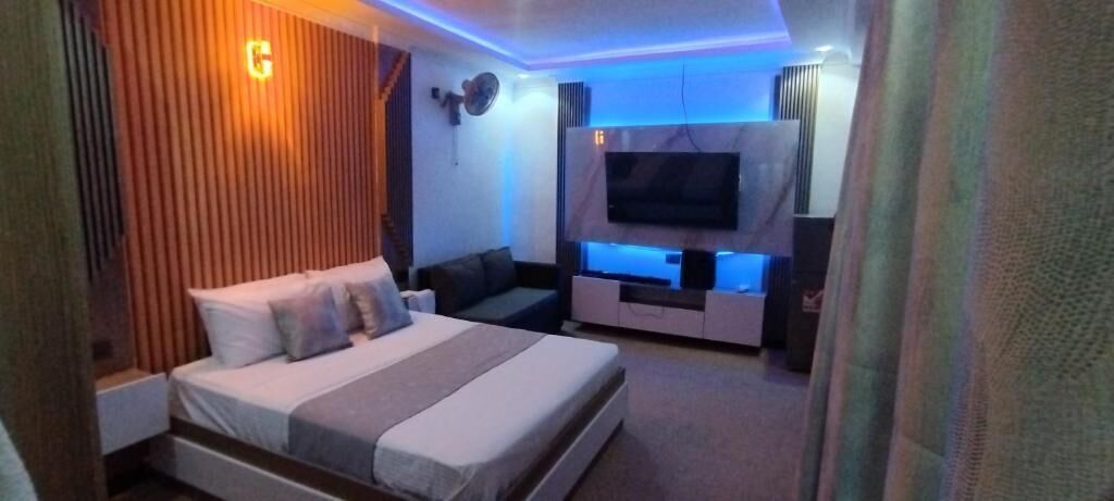 Ein modernes Schlafzimmer mit einem Bett, einem Fernseher und einer eingebauten Unterhaltungseinheit.