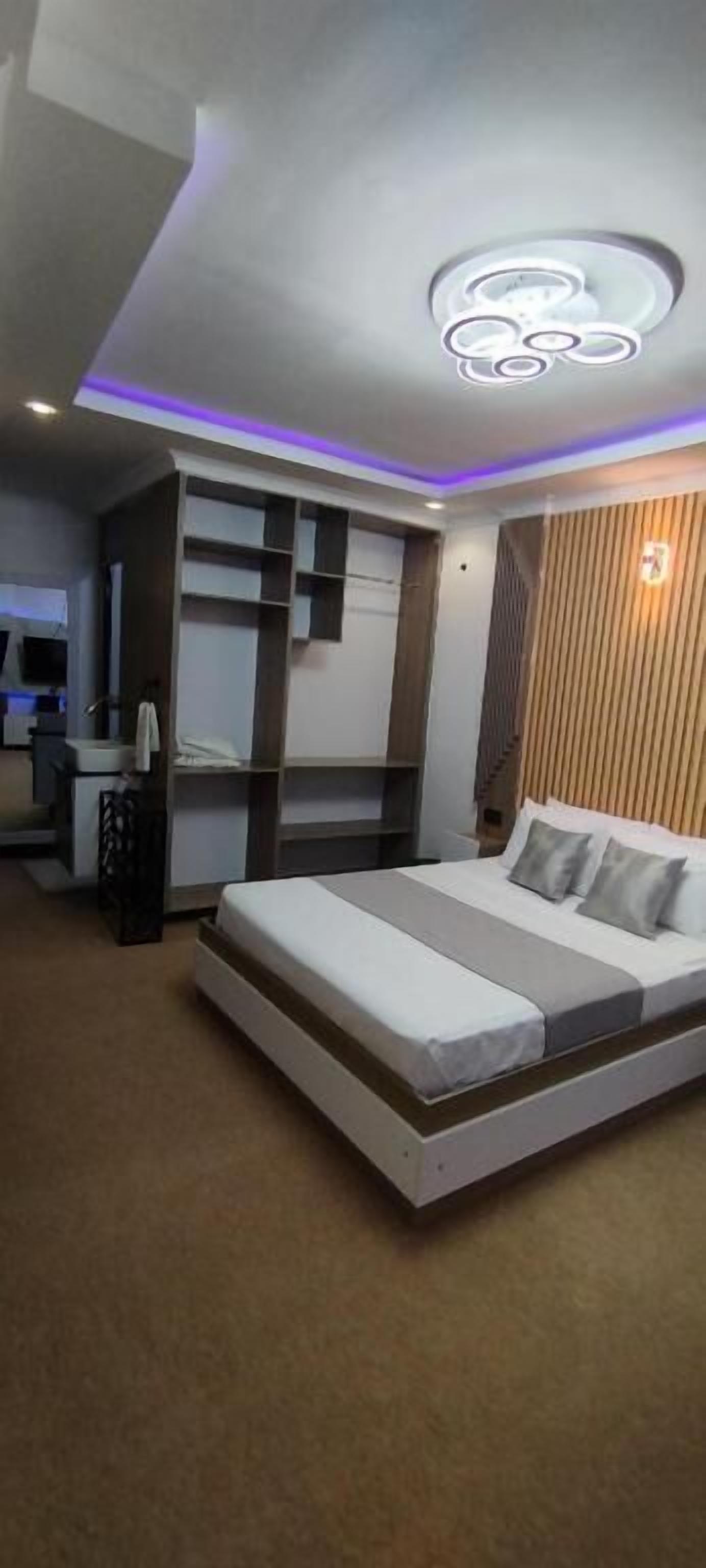 A modern hotel room with a bed, a desk, and a vanity.
