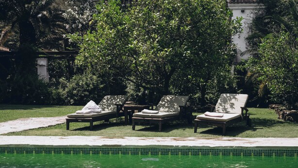 Ein Poolbereich mit Liegestühlen und einem gefliesten Pool.