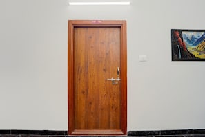 Una puerta de madera con un picaporte metálico y un cartelito encima.