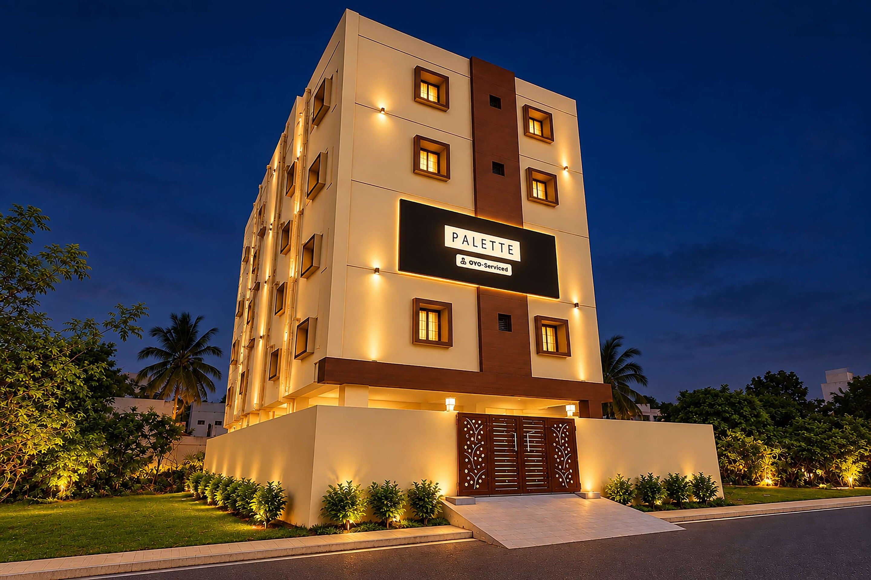 A multi-story hotel building with a sign reading 'PALETTE' and 'OYO-Serviced' indicating a partnership.