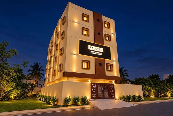 A multi-story hotel building with a sign reading 'PALETTE' and 'OYO-Serviced' indicating a partnership.