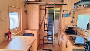 A compact, wooden interior with a bunk bed, a kitchen area, and a dining space. - Tiny House Prum - Natururlaub in der Eifel (Pruem)