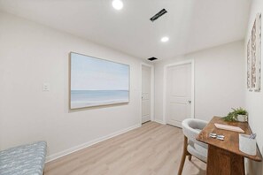 A room with a wooden floor, a painting of a beach, a desk with a chair, and a door. - Bradley Beach Compound:2 homes, sleeps 11,+parking (Bradley Beach)
