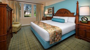 Una habitación de hotel con una cama grande, una silla, un escritorio y una ventana con cortinas.