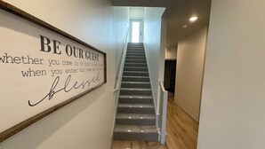A staircase leading to a landing with a sign on the wall. - 3-bedroom Luxury townhome in brilliant Edmond 5 min to UCO (Edmond)