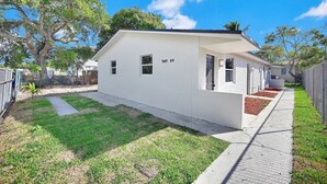 Um edifício térreo com telhado plano, um pequeno alpendre e o número '807 09' na lateral.