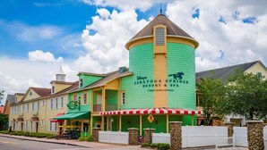 Ein Gebäude mit grüner Fassade und einem Turm, beschriftet mit 'Disney's Saratoga Springs Resort & Spa'.