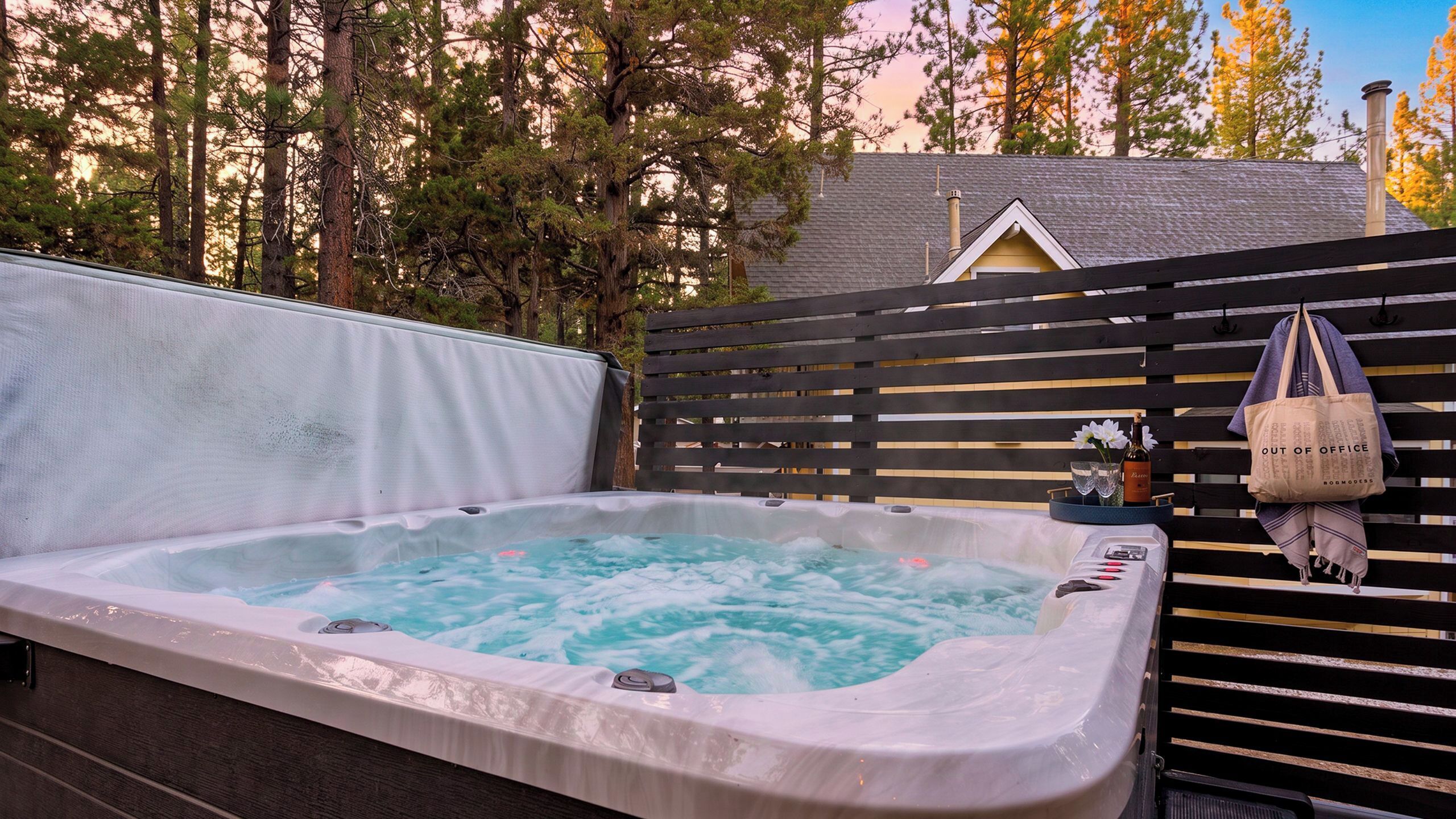 Un jacuzzi con una cerca de madera y una bolsa colgada.