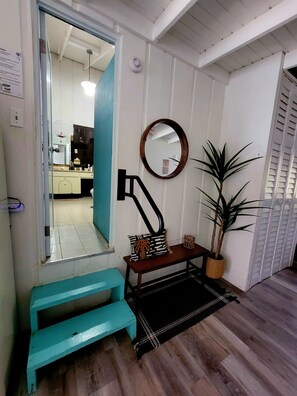 A room with a wooden bench, a mirror, a potted plant, and a tiled floor. - JV BEACHFRONT APARTMENT: YOUR DREAM OCEANVIEW SPOT (Añasco)