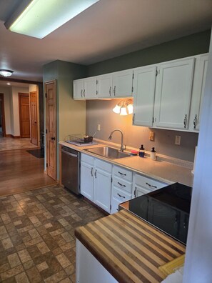 A kitchen with white cabinets, a stainless steel sink, and a wooden countertop. - House just minutes from the Yellowstone river. (Livingston)