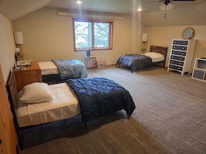 A bedroom with two beds, a window, a dresser, and a mirror. - House just minutes from the Yellowstone river. (Livingston)
