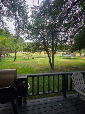 Una terraza con una parrilla, una mesa de picnic y una silla.