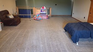 Ein Zimmer mit Deckenventilator, einem Etagenbett, einem Sessel und einem Bett.