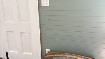 A room with a wooden chest, a framed certificate on the wall, and a door.