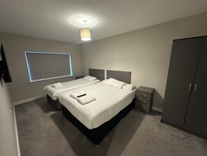 A hotel room with a bed, bedside tables, a wardrobe, and a ceiling light.