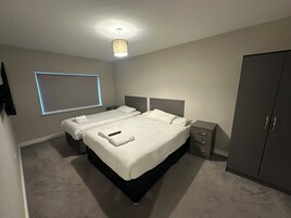A hotel room with a bed, bedside tables, a wardrobe, and a ceiling light.