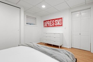 A bedroom with a bed, a dresser, and a wardrobe.