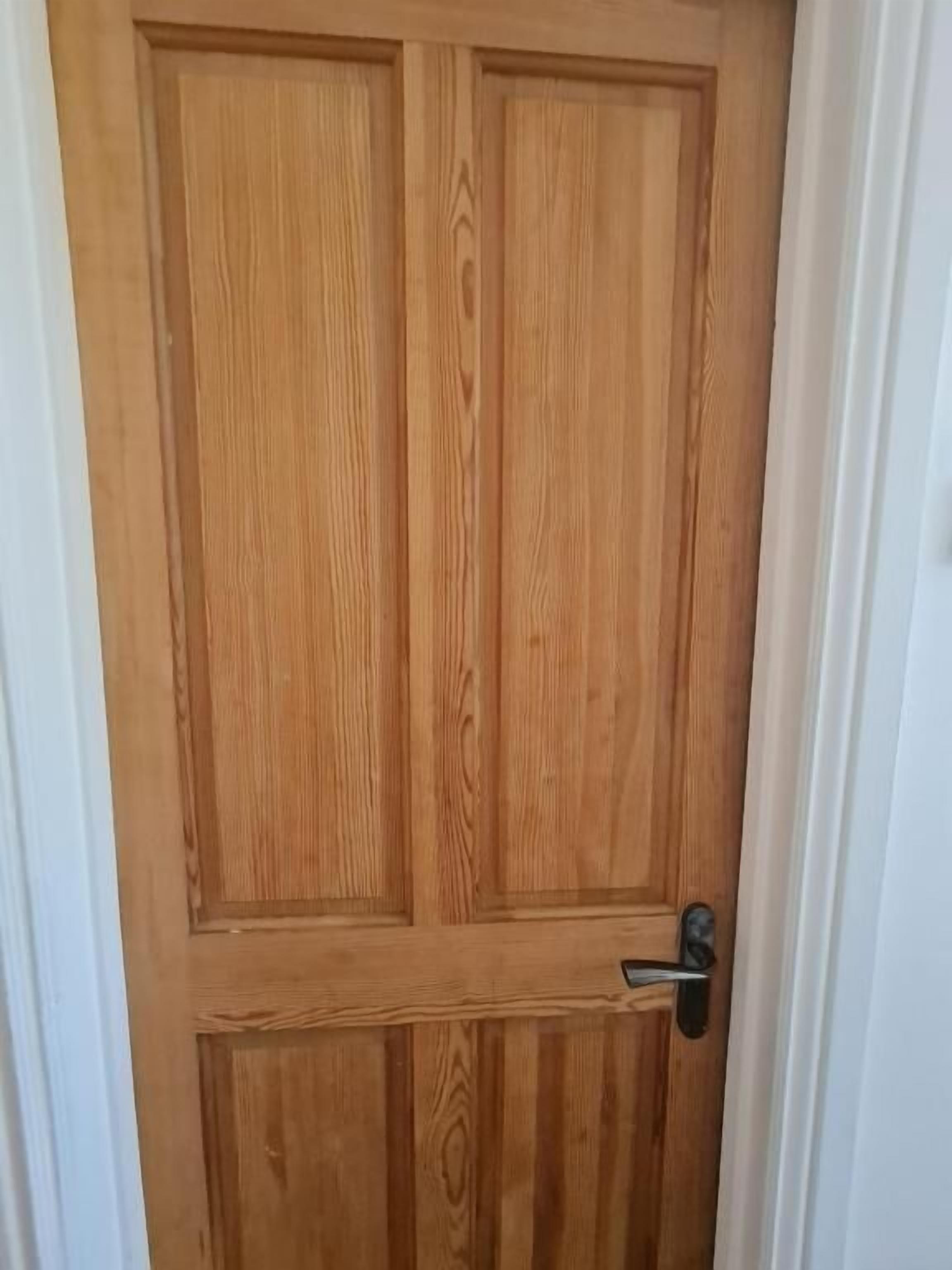 Une porte en bois avec une poignée en métal et un trou de serrure.