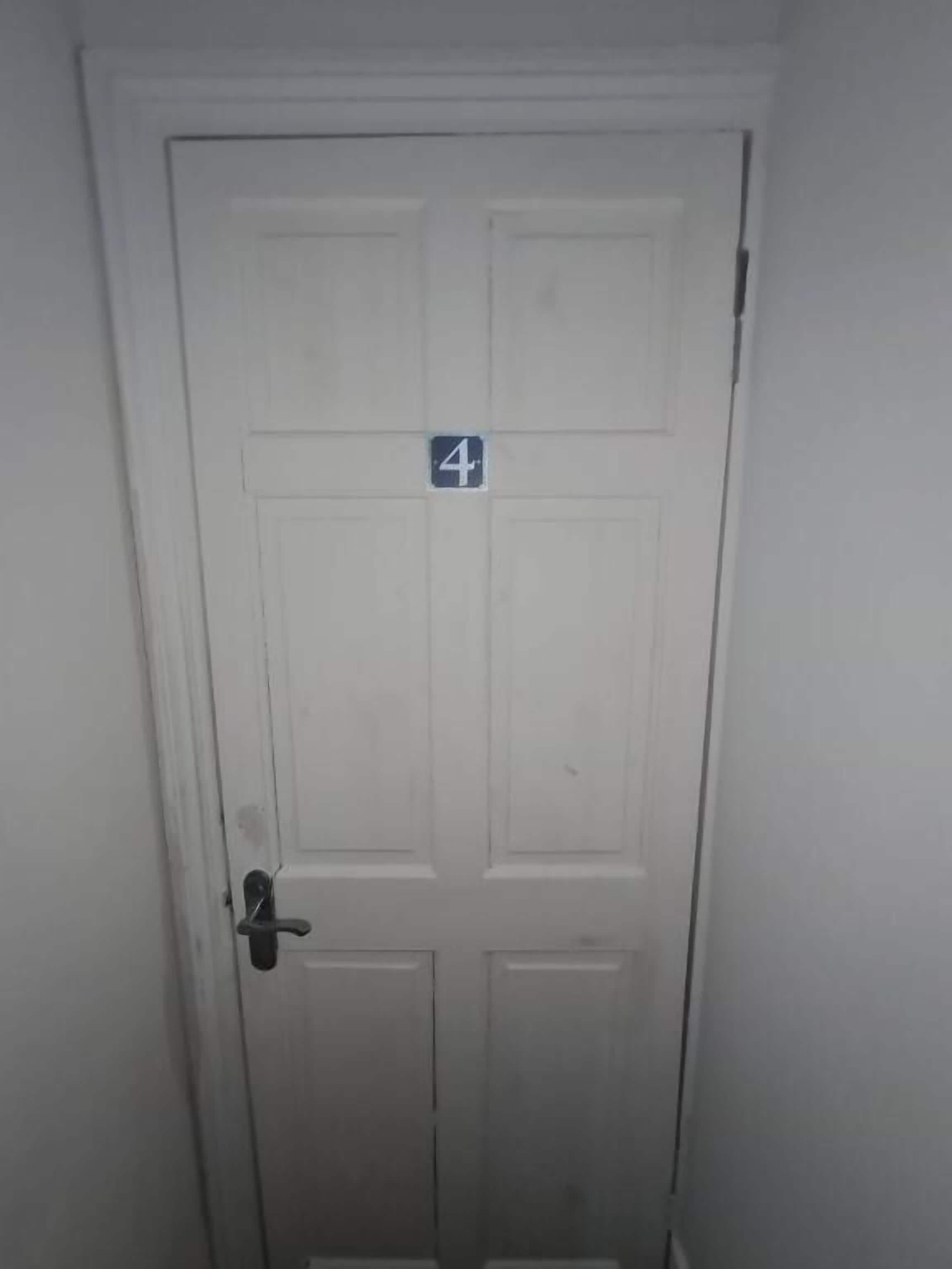 A white door with a number '4' sign on it.
