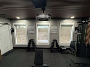 Ein Fitnessstudio mit Trainingsgeräten, Fenstern und Motivationspostern.