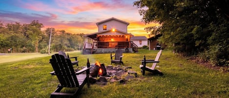 A house with a deck, outdoor seating, and a fire pit.