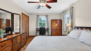 A bedroom with a bed, a desk, a wardrobe, a ceiling fan, and a window with curtains. - Ohana Nature Escape by Avantstay Creekside + Firepit + Grill Waterfall + Beaver Pond Walks (Catskill)