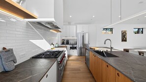 A modern kitchen with a central island, stainless steel appliances, and a wooden countertop. - Olive & Oak by Avantstay 75-ft Lap Pool + Hot Tub + Sauna 40 Private Acres (Glen Ellen)
