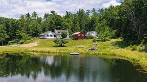 A lakeside property with a pond, a dock, and a row of houses. - Ashokan Acres by Avantstay Private 125-acre Retreat Pond + Hot Tub + Sauna + Trails (Kingston)