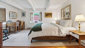 A bedroom with a bed, bedside table, lamp, desk, chair, and a window with a view of a red building. - Ashokan Acres by Avantstay Private 125-acre Retreat Pond + Hot Tub + Sauna + Trails (Kingston)