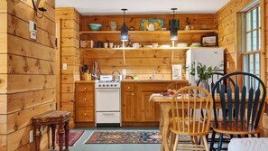 A wooden interior with a kitchen, dining area, and a small seating space. - Ashokan Acres by Avantstay Private 125-acre Retreat Pond + Hot Tub + Sauna + Trails (Kingston)