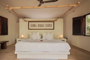 A bedroom with a bed, bedside tables, a ceiling fan, and framed artwork on the wall. - Casa Macaria (Santa Maria Colotepec)