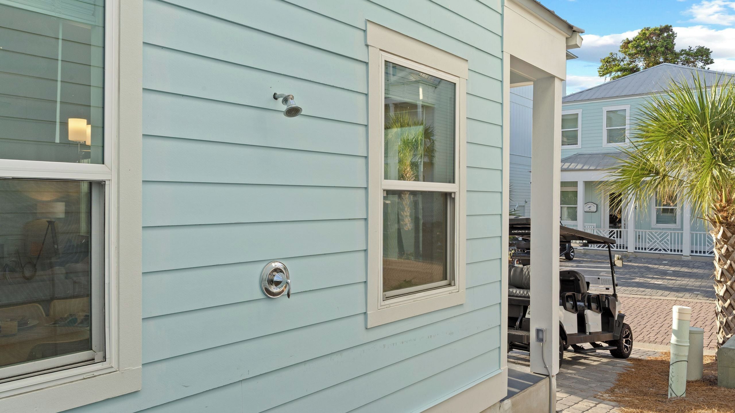 A light blue building with two windows and a garage door.