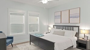 Ein Schlafzimmer mit einem Bett, Nachttischen, einem Schreibtisch und einem Sessel.