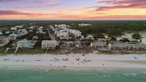Luftaufnahme einer Küstenstadt mit Strandhäusern, einem Sandstrand und freiem Blick auf den Ozean.