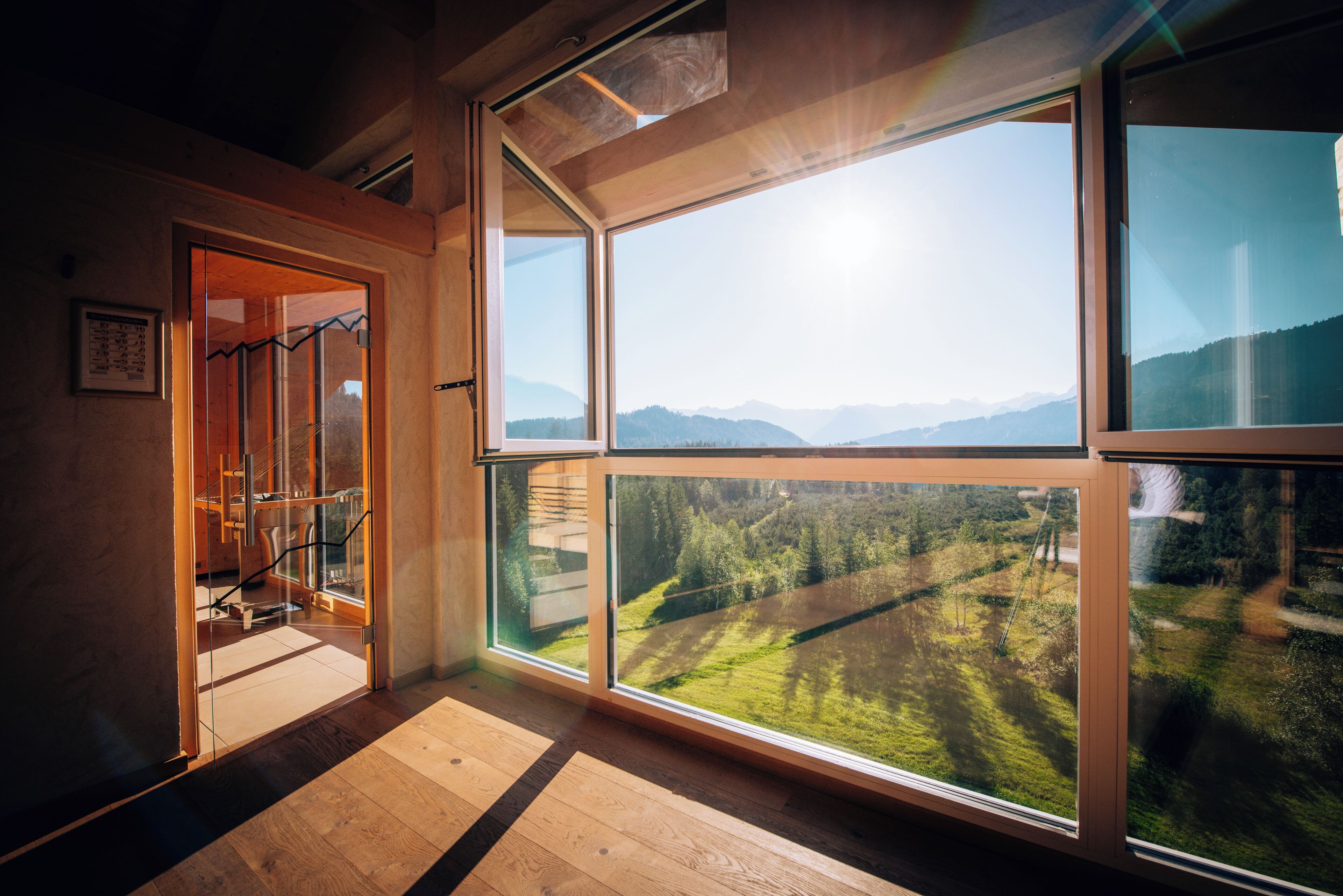 Ein Zimmer mit großen Fenstern und Blick auf eine Berglandschaft.