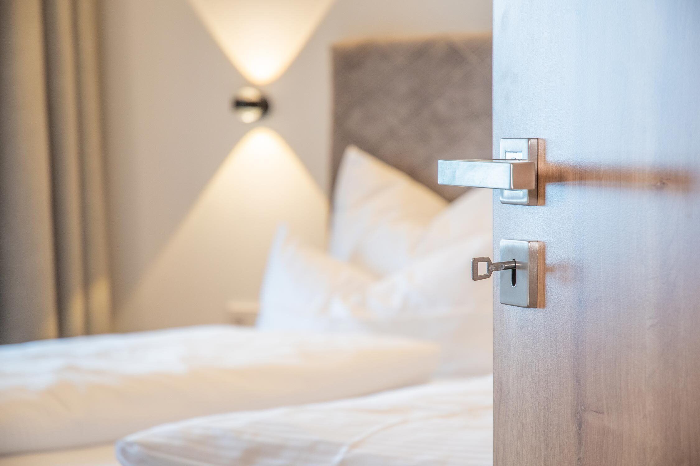 Ein Hotelzimmer mit einem Bett, einem Nachttisch und einer Wandlampe.