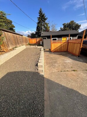 A backyard with a gravel area, a wooden fence, and a small shed. - Modern Cottage near Park/Lake Access (Bremerton)