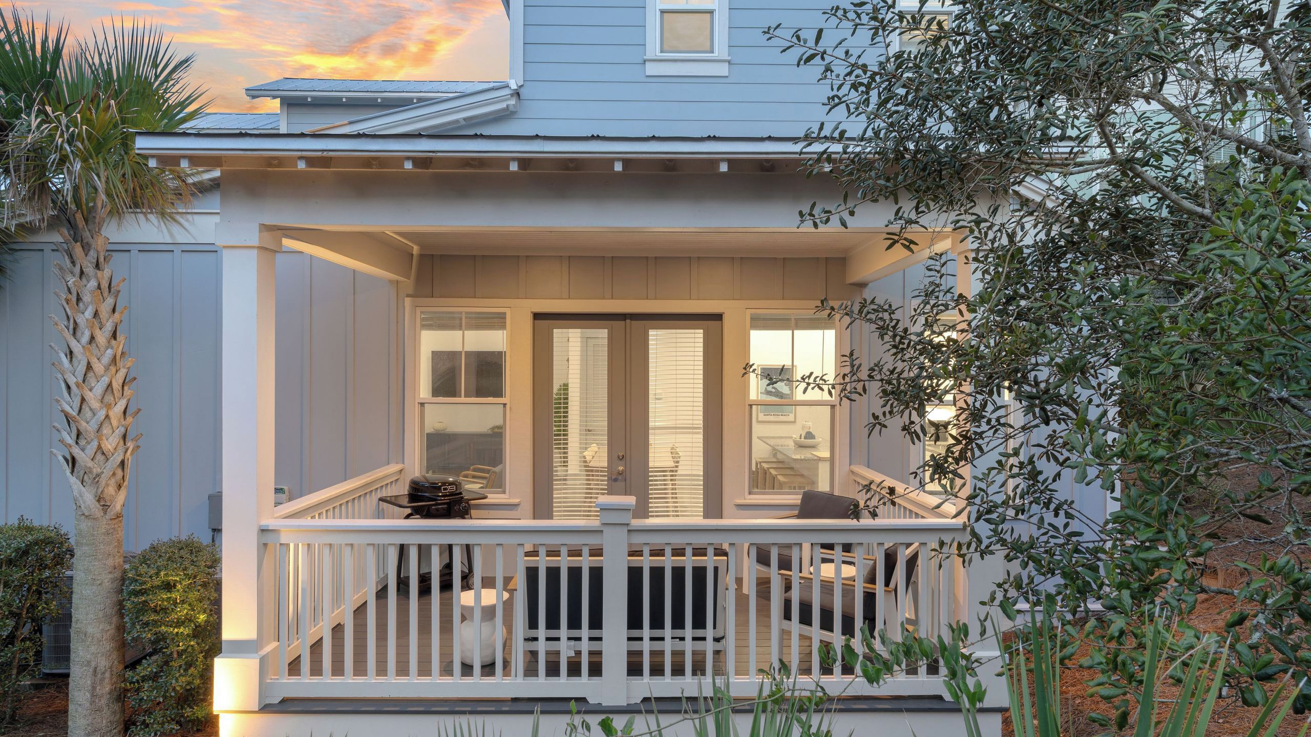 Une maison à deux étages dotée d’un porche abrité et d’une petite terrasse.
