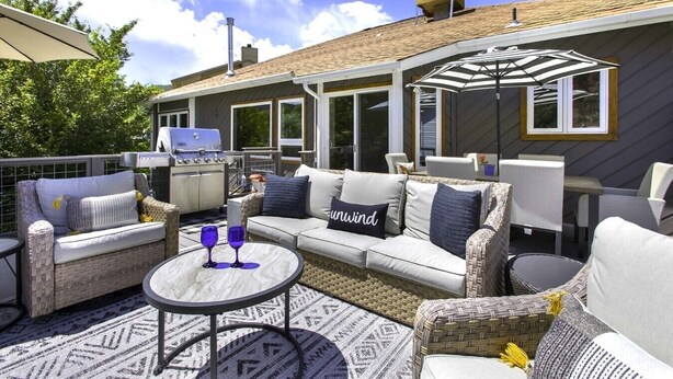 An outdoor patio with a sofa, chairs, a grill, and a table with glasses. - River View Ridge w/ Hot Tub/Dog Friendly (Glenwood Springs)