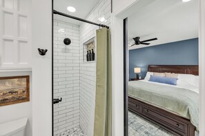 A bathroom with white subway tiles, a shower curtain, and a towel rack.