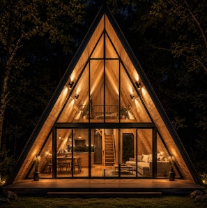 A triangular wooden cabin with a glass facade, a dining area, and a living room with a sofa and a coffee table. - Hidden Oaks Resort - White Oak (Walling)