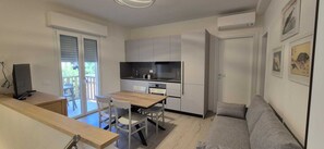 A compact living space with a kitchenette, a dining area, and a sofa. - TIRRENO APARTMENT, NEW, TERRACE, PARKING SPACE, AIR CONDITIONING, INTERNET, 100 M FROM THE BEACH (San Vincenzo)