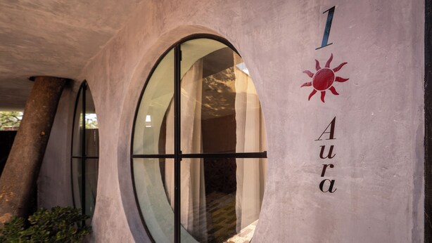 Un edificio con un ventanal circular y el número '1' y la palabra 'Aura' en la pared.