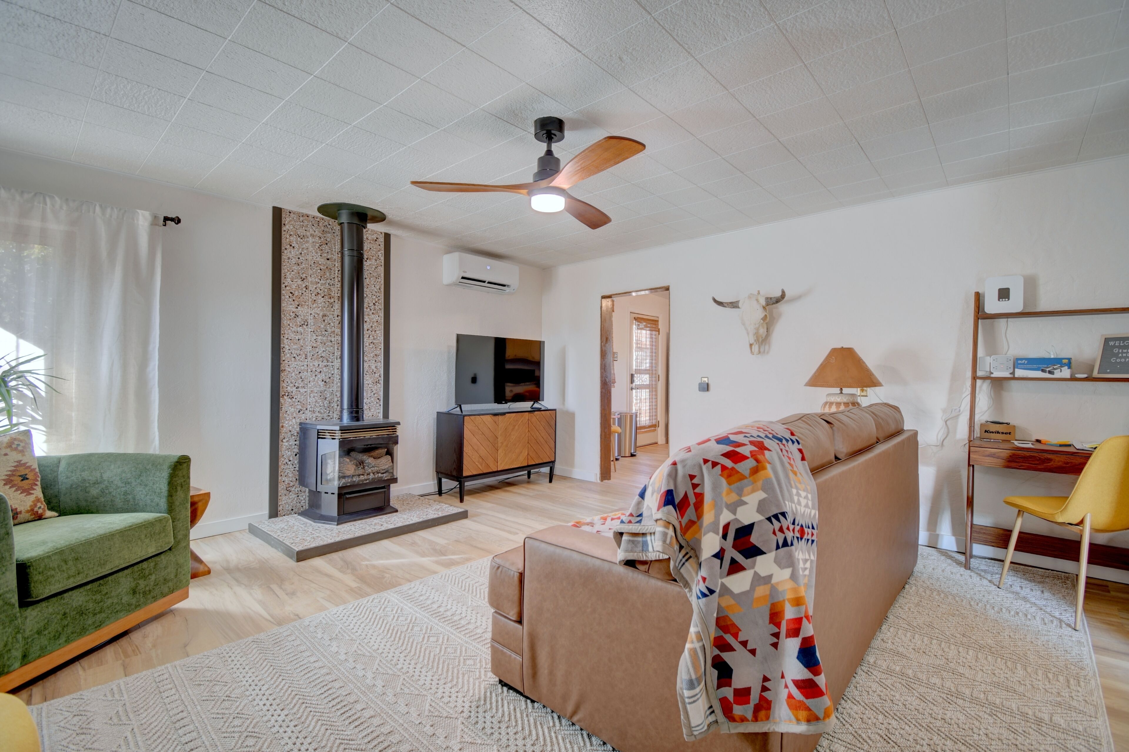 A living room with a fireplace, sofa, and a ceiling fan.