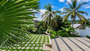 A landscaped garden with a patterned lawn and paved walkway. - EVERGREEN VILLA (Dar es Salaam)