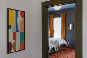 A room with a bed, a window with curtains, and a wall-mounted mirror. - Walk to Mass Ave , Charming 3BR with 2 Kings, Garage & fire pit (Indianapolis)