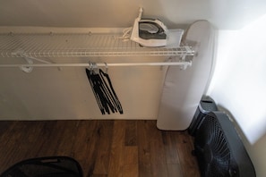 A room with a white ironing board, a white radiator, and a black fan. - Walk to Mass Ave , Charming 3BR with 2 Kings, Garage & fire pit (Indianapolis)